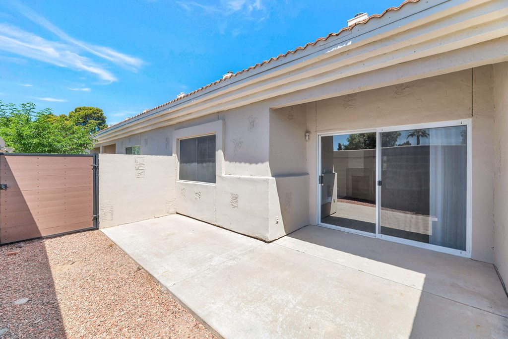 a patio in front of a house with a sliding glass door
