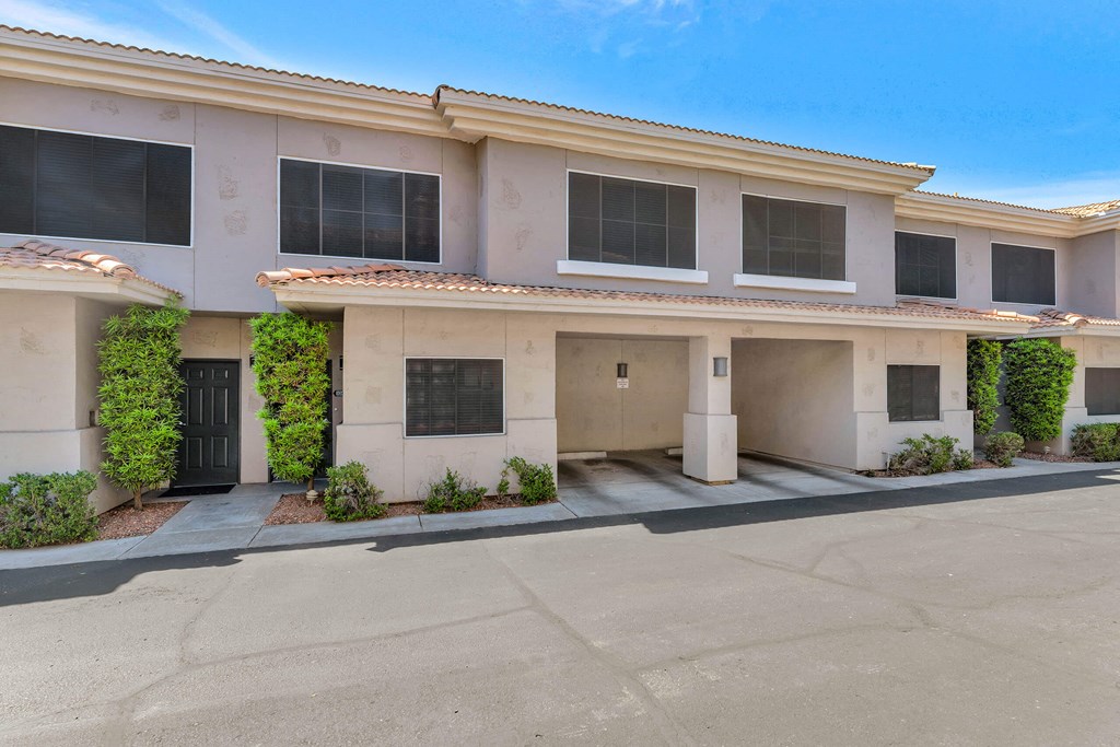 a white building with a driveway and a black door