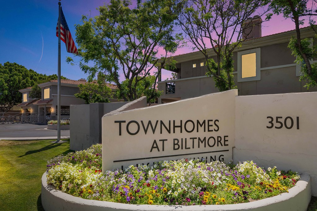 a sign for the townhomes at biltmore in front of a flag