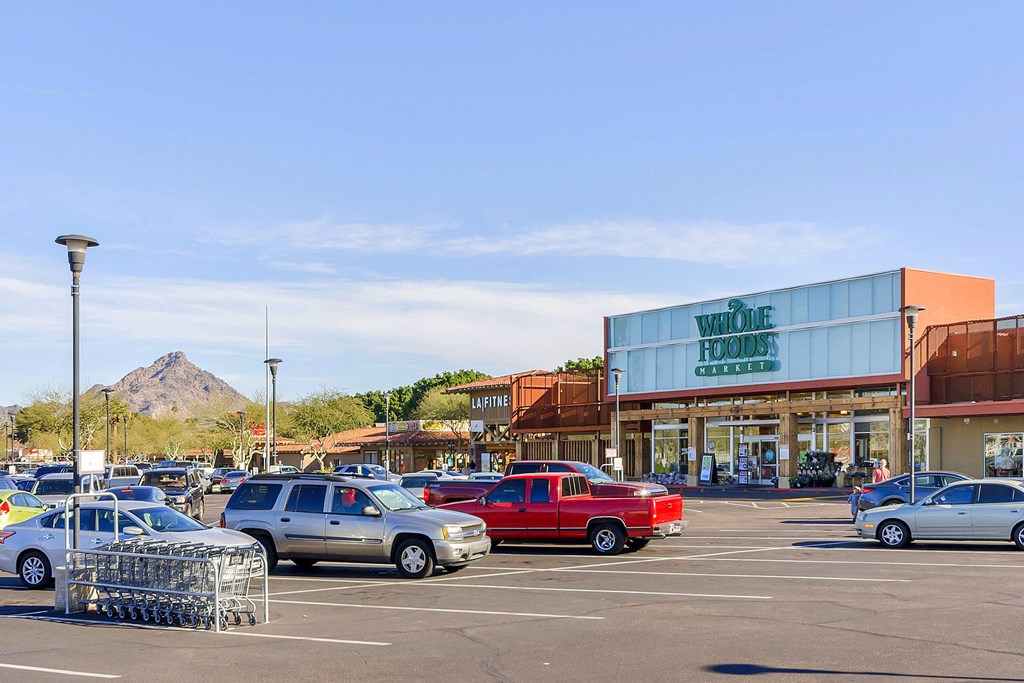 a parking lot filled with cars in front of a shopping center
