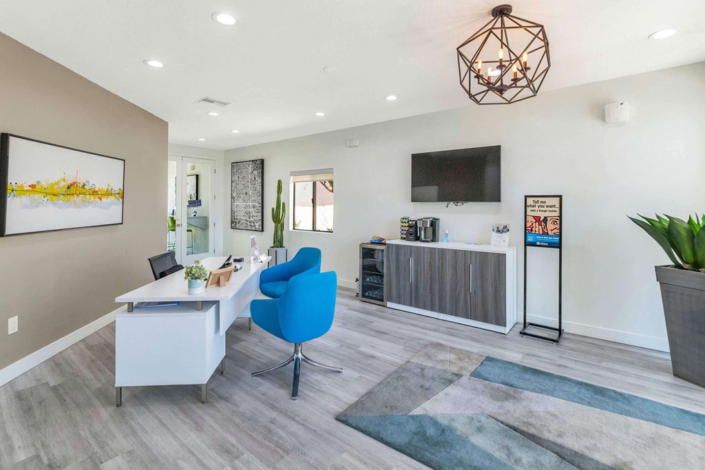 a living room with a desk and a chair and a tv