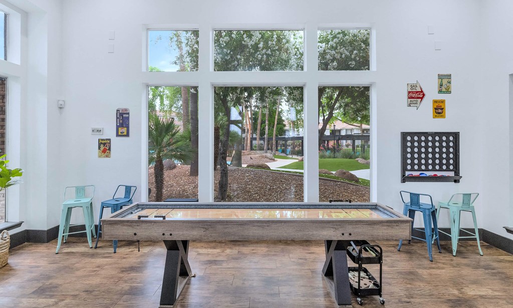 a pool table in a room with windows and a view of a park at Montage at Pecos Ranch Apartments, Chandler, 85286
