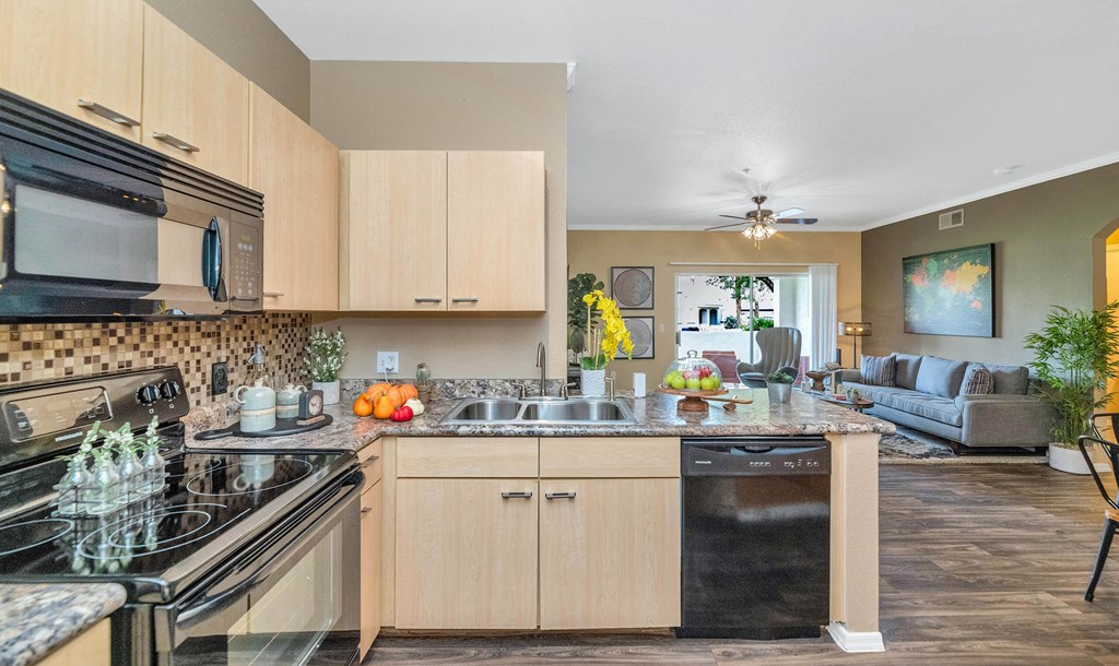 A kitchen with a black stove top oven and a black microwave above it at Montage at Pecos Ranch Apartments, Chandler, AZ
