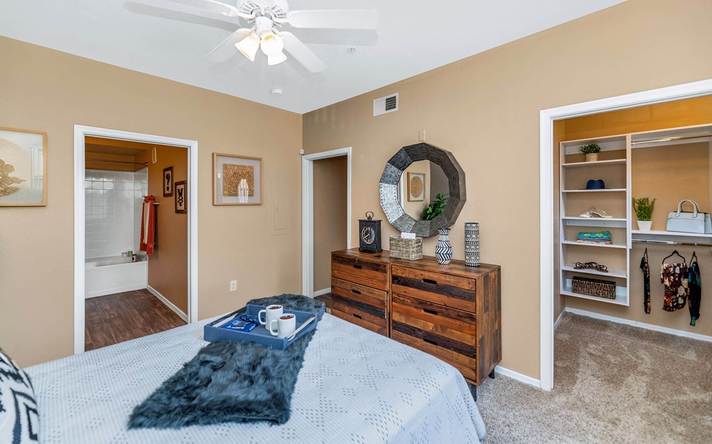 a bedroom with a bed and a dresser and a ceiling fan at Montage at Pecos Ranch Apartments, Chandler