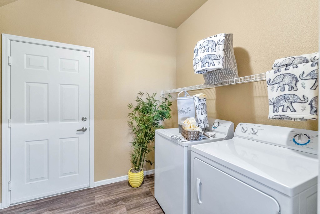 the washer and dryer in a laundry room with a white door at Montage at Pecos Ranch Apartments, Arizona, 85286