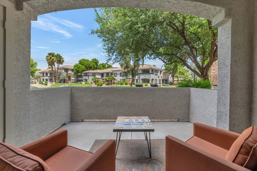 a patio with couches and a table in front of a tree at Montage at Pecos Ranch Apartments, Chandler
