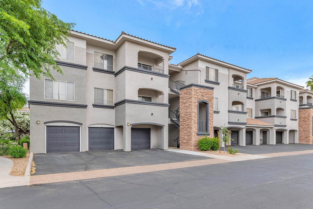 a street view of an apartment building with garage doors at Montage at Pecos Ranch Apartments, Chandler, 85286