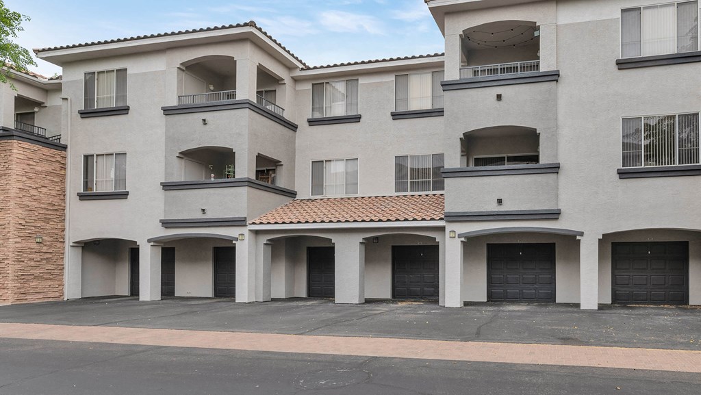 A large white building with a red tile roof and multiple balconies at Montage at Pecos Ranch Apartments, Chandler, Arizona