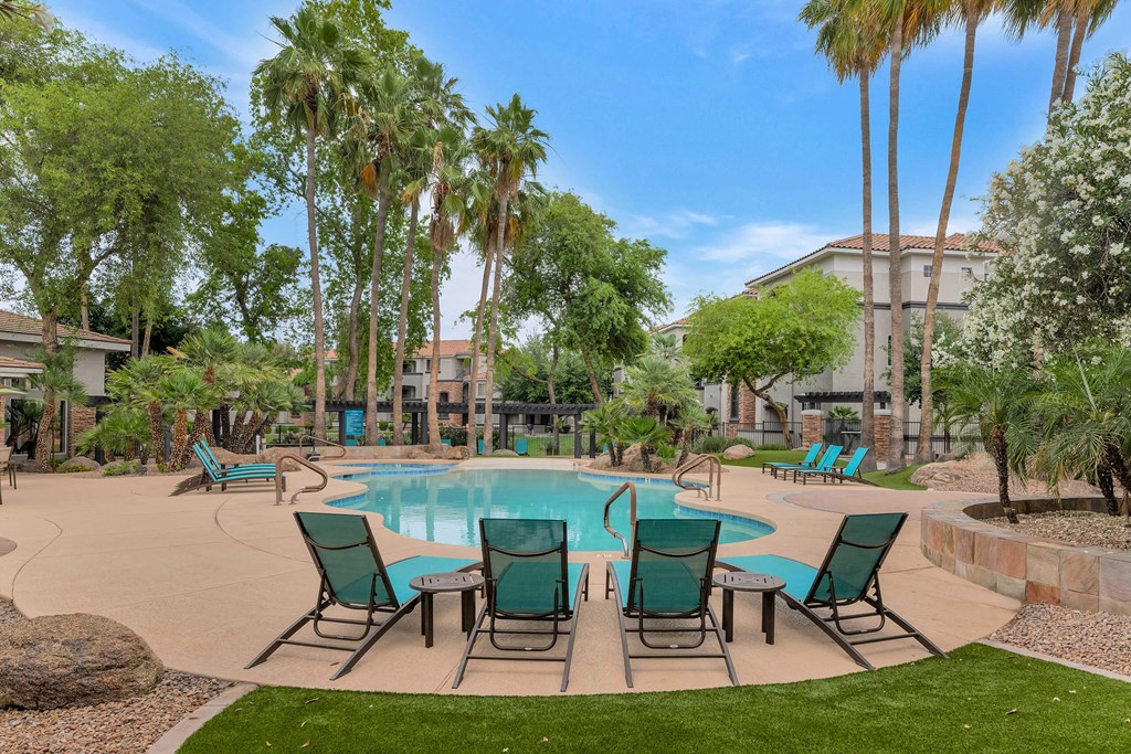 a swimming pool with patio furniture and palm trees at Montage at Pecos Ranch Apartments, Chandler, 85286