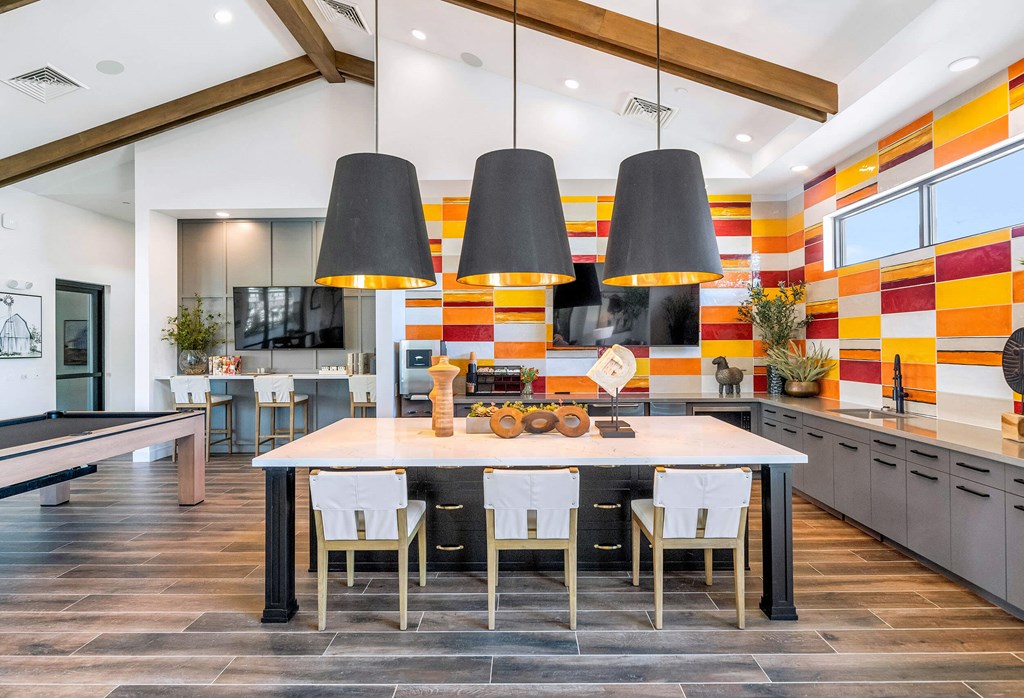 a dining room with a table and chairs in front of a kitchenat Weylyn Luxury Apartments, Laveen, 85339