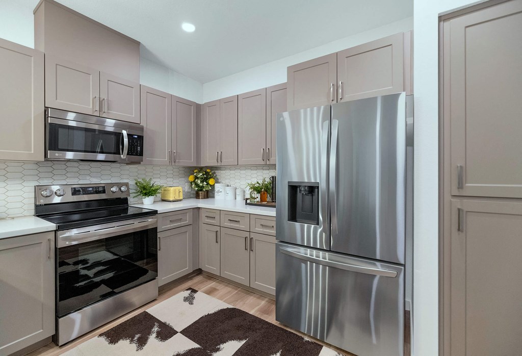 a kitchen with stainless steel appliances and white cabinets at Weylyn Luxury Apartments, Laveen, 85339