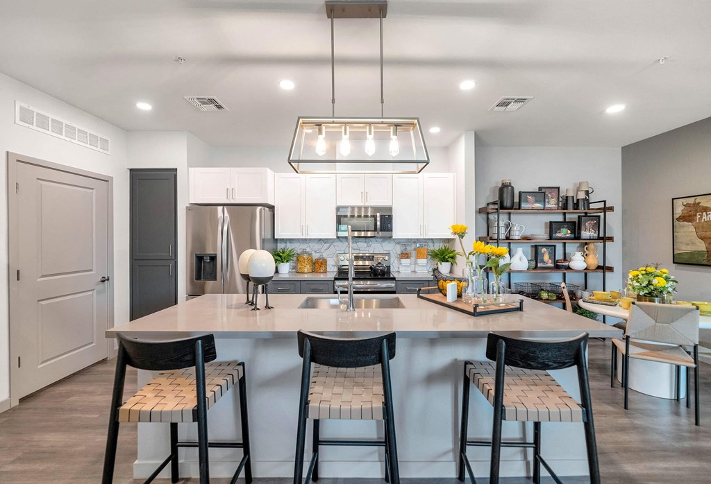 a kitchen with a large island with three stools at Weylyn Luxury Apartments, Arizona