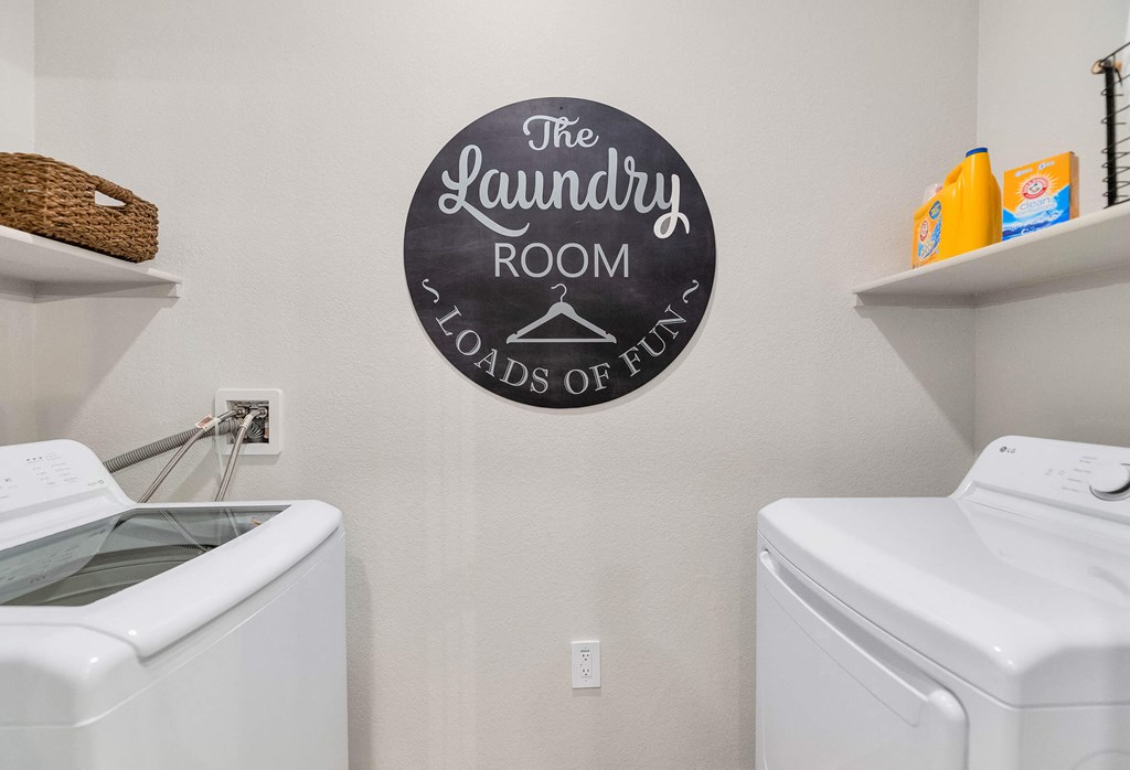 the laundry room has a washer and dryer and a sign on the wall at Weylyn Luxury Apartments, Laveen, Arizona