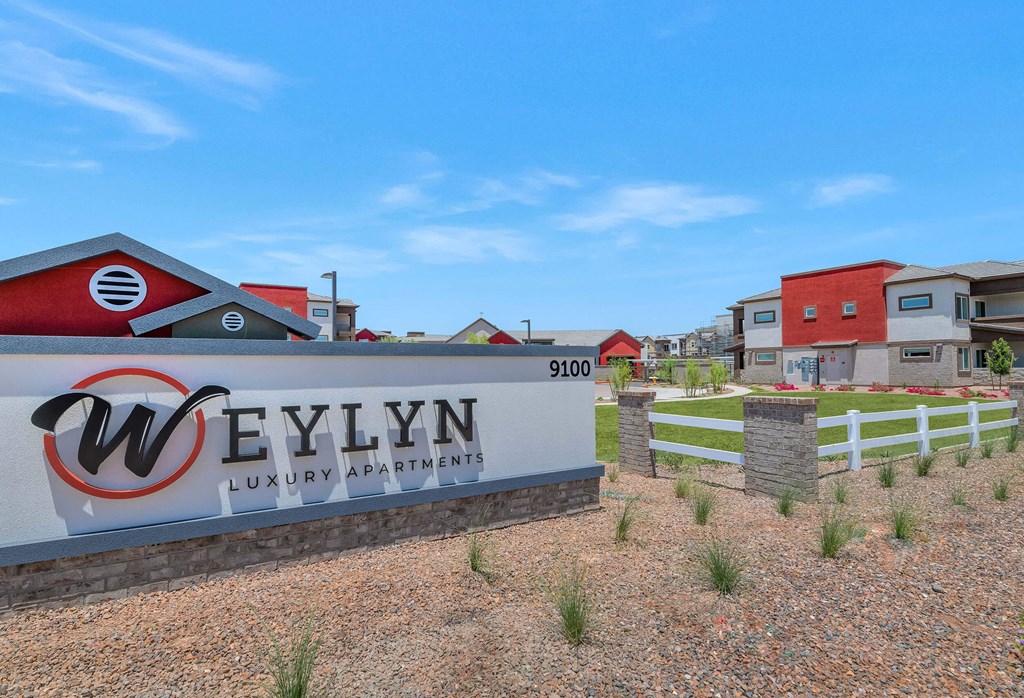 a sign luxury apartments with houses in the background at Weylyn Luxury Apartments, Laveen, Arizona