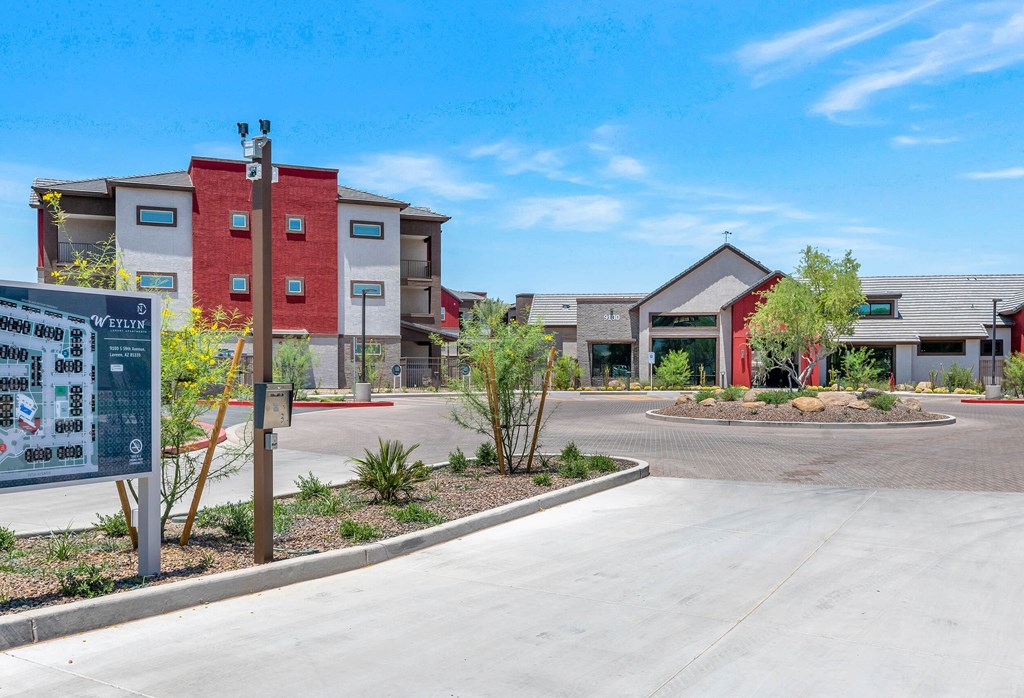 an empty parking lot in front of a building with apartments in the background at Weylyn Luxury Apartments, Laveen, AZ, 85339