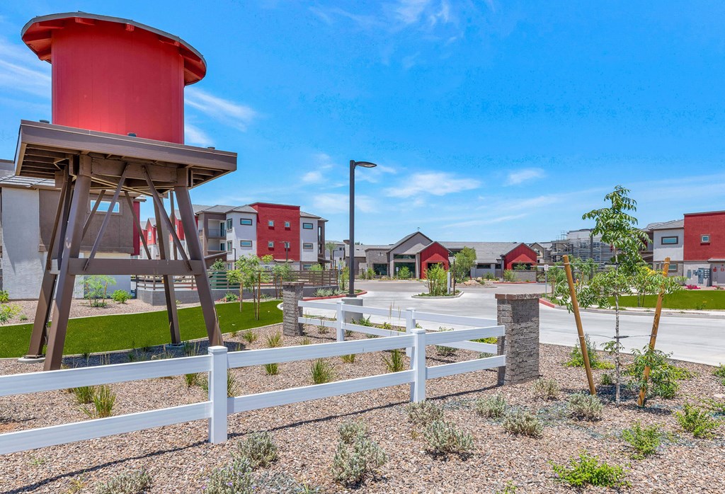 a red water tower sits in the middle of a parking lot at Weylyn Luxury Apartments, Arizona