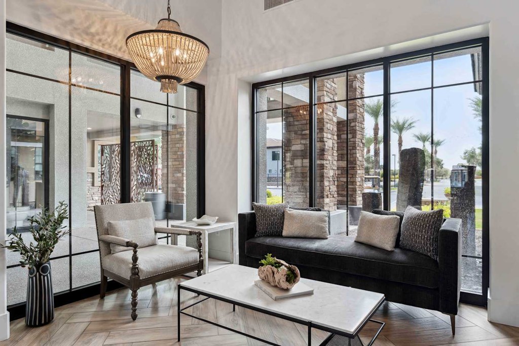 A modern living room with a black couch, a white coffee table, and a large window. at The Laurel Apartments, Chandler, 85286