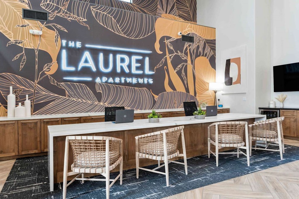 A conference room with a large table and chairs with a backdrop that says  at The Laurel Apartments, Chandler