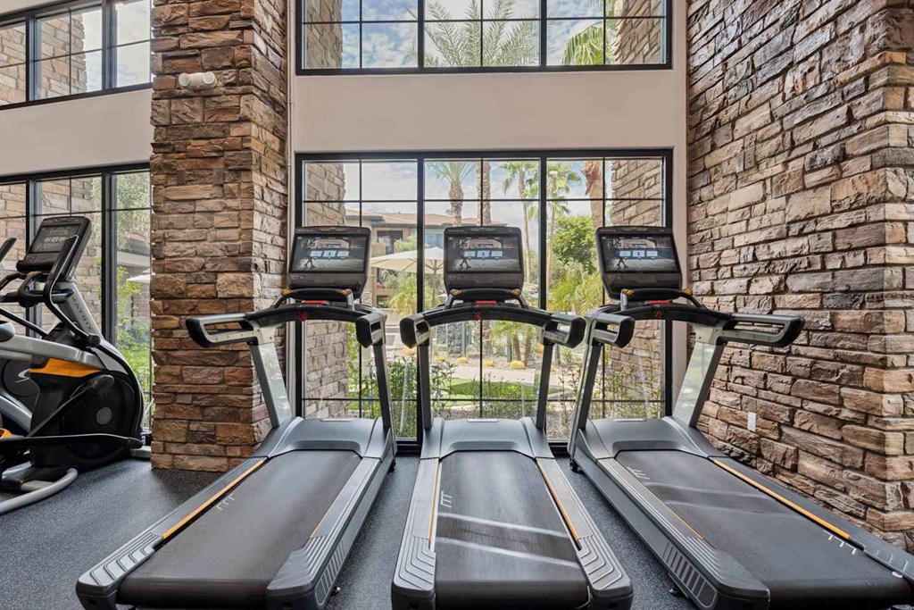 A gym with treadmills and a brick wall. at The Laurel Apartments, Chandler, 85286