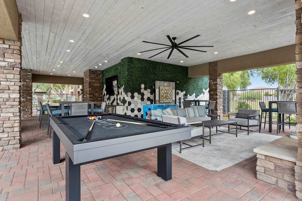 A pool table is in the middle of a room with a ceiling fan. at The Laurel Apartments, Arizona, 85286
