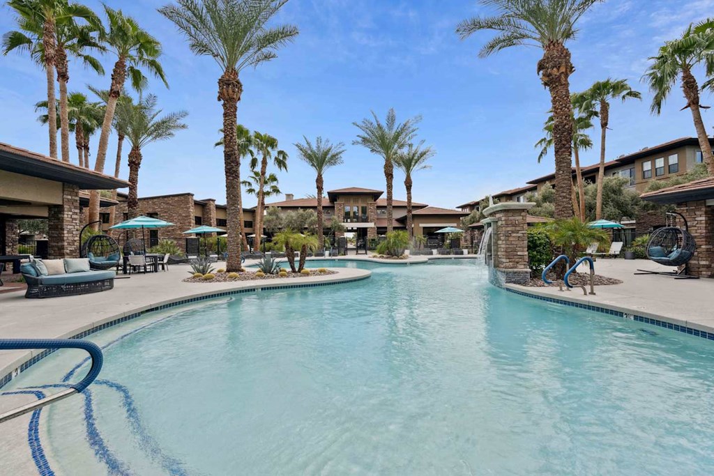 A swimming pool surrounded by palm trees and lounge chairs. at The Laurel Apartments, Chandler, 85286