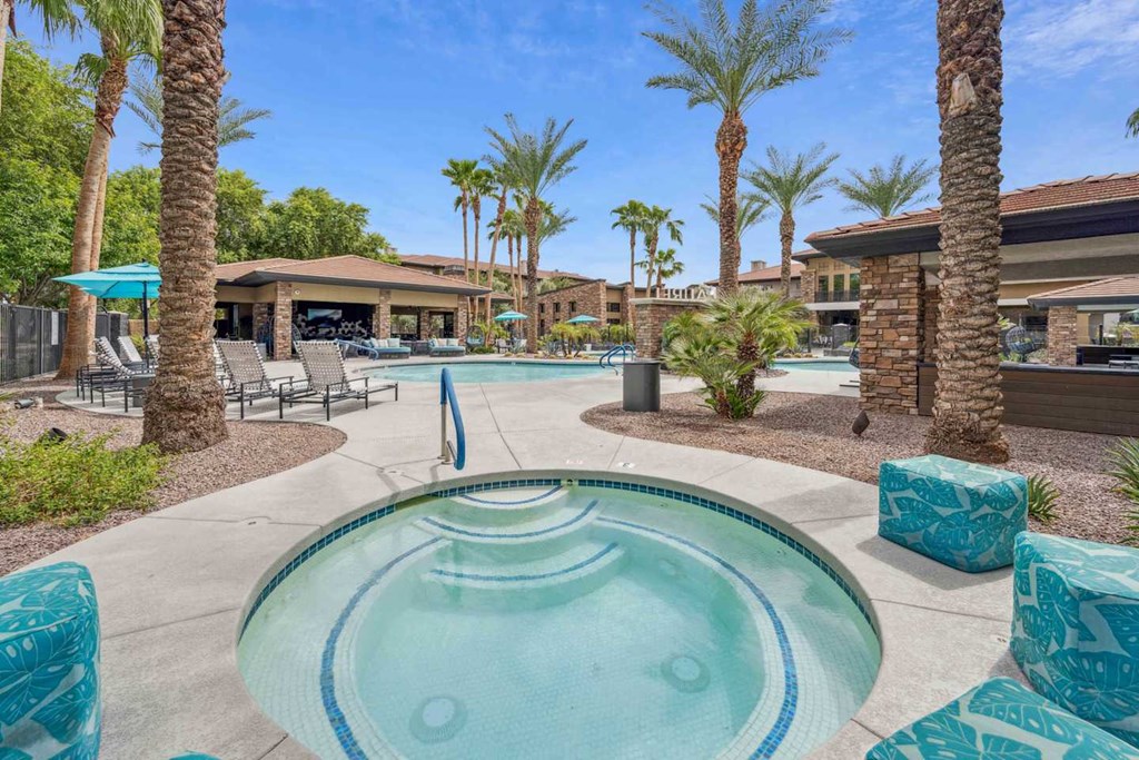 A pool surrounded by palm trees and lounge chairs. at The Laurel Apartments, Arizona, 85286