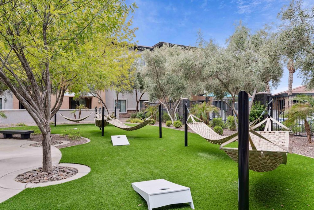 A backyard with a white hammock and a white bench. at The Laurel Apartments, Chandler Arizona