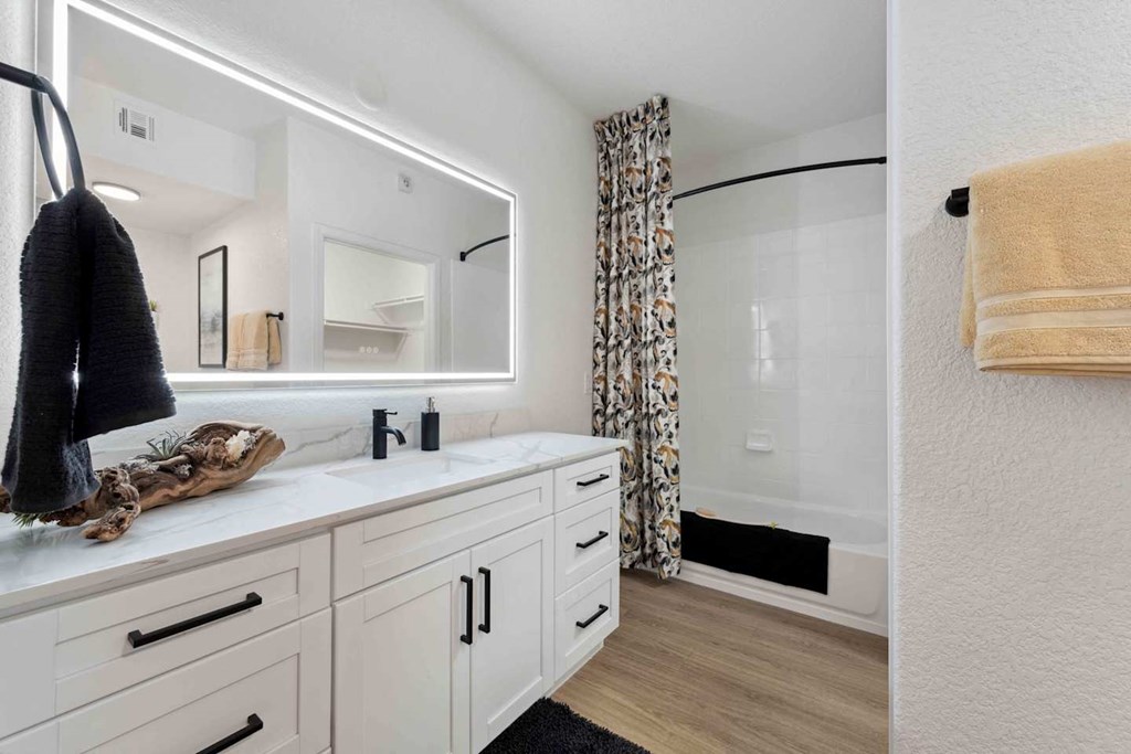 A bathroom with a white vanity and a mirror above it at The Laurel Apartments, Chandler, AZ  .