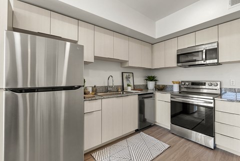 A modern kitchen with a stainless steel refrigerator and oven.