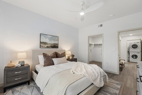 A bedroom with a large bed and a painting on the wall.