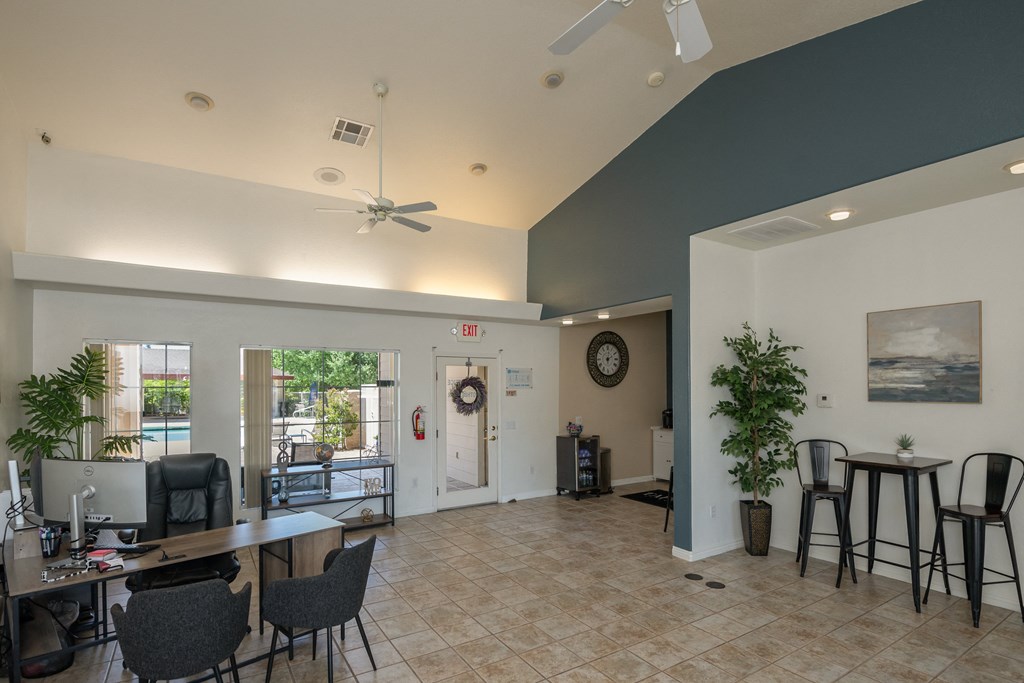 a living room with a table and chairs and a ceiling fan