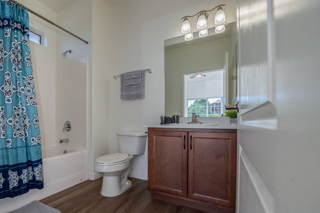 a bathroom with a toilet sink and shower and a mirror