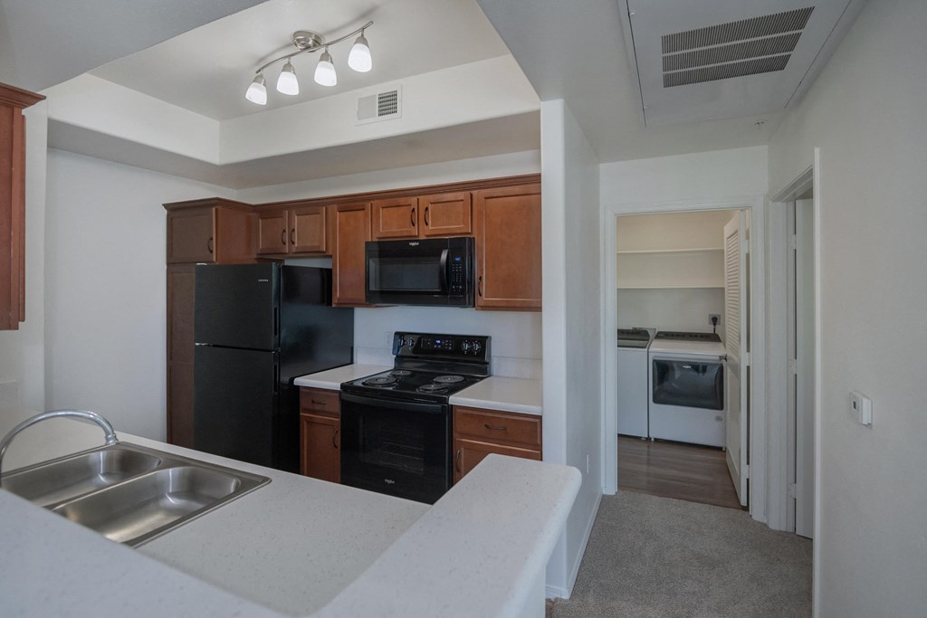 an empty kitchen with black appliances and white counter tops