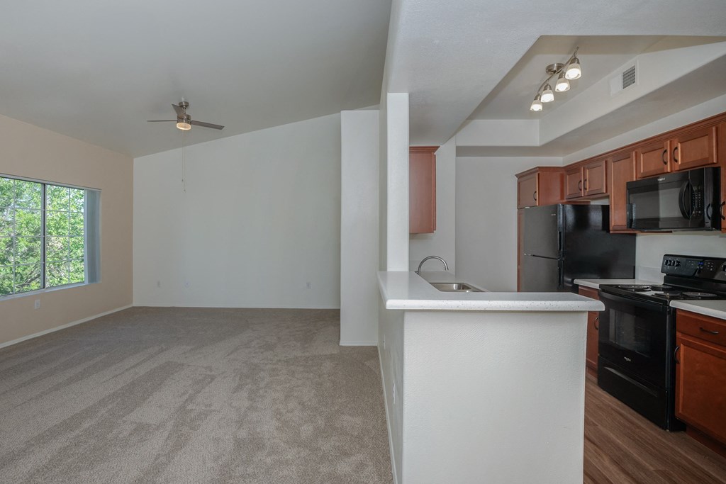 an empty kitchen and living room with a large window