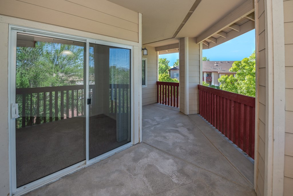 a covered porch with glass doors and a patio