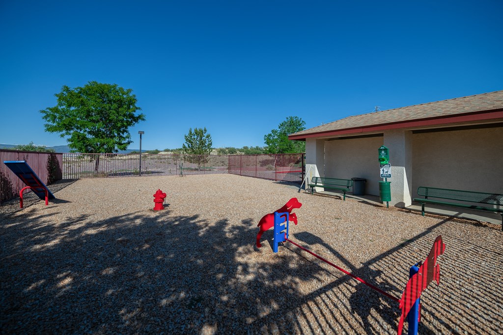 two red fire hydrants in a fenced in play area with a building
