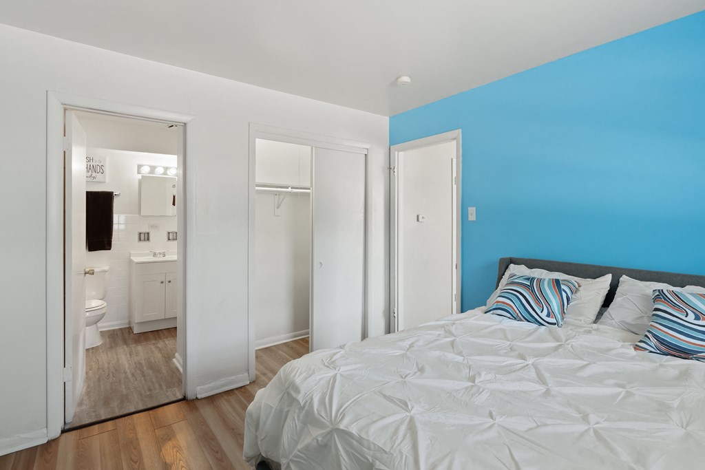 a bedroom with a bed and a door to a bathroom