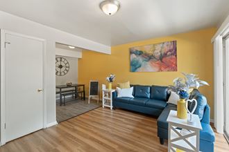 a living room with yellow walls and a blue couch