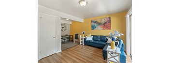 a living room with yellow walls and a blue couch
