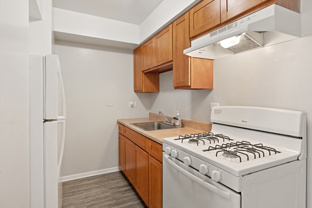 a kitchen with white appliances and wooden cabinets