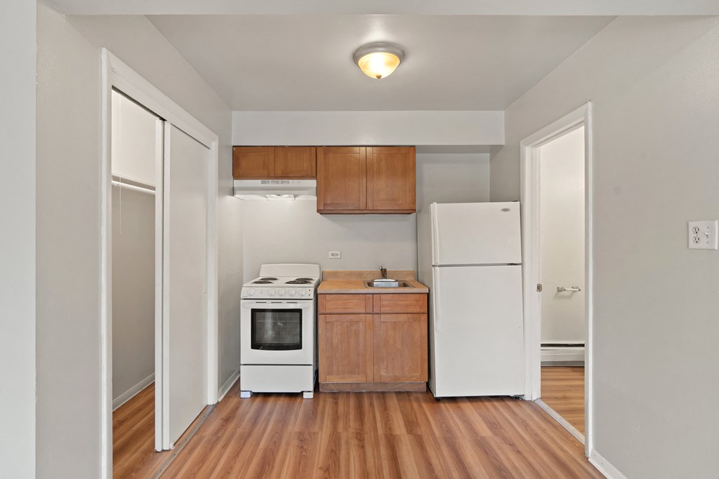 a kitchen with a white refrigerator freezer next to a stove top oven