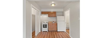 a kitchen with a white refrigerator freezer next to a stove top oven