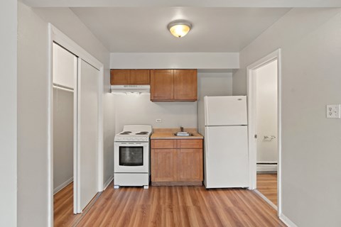 a kitchen with a white refrigerator freezer next to a stove top oven
