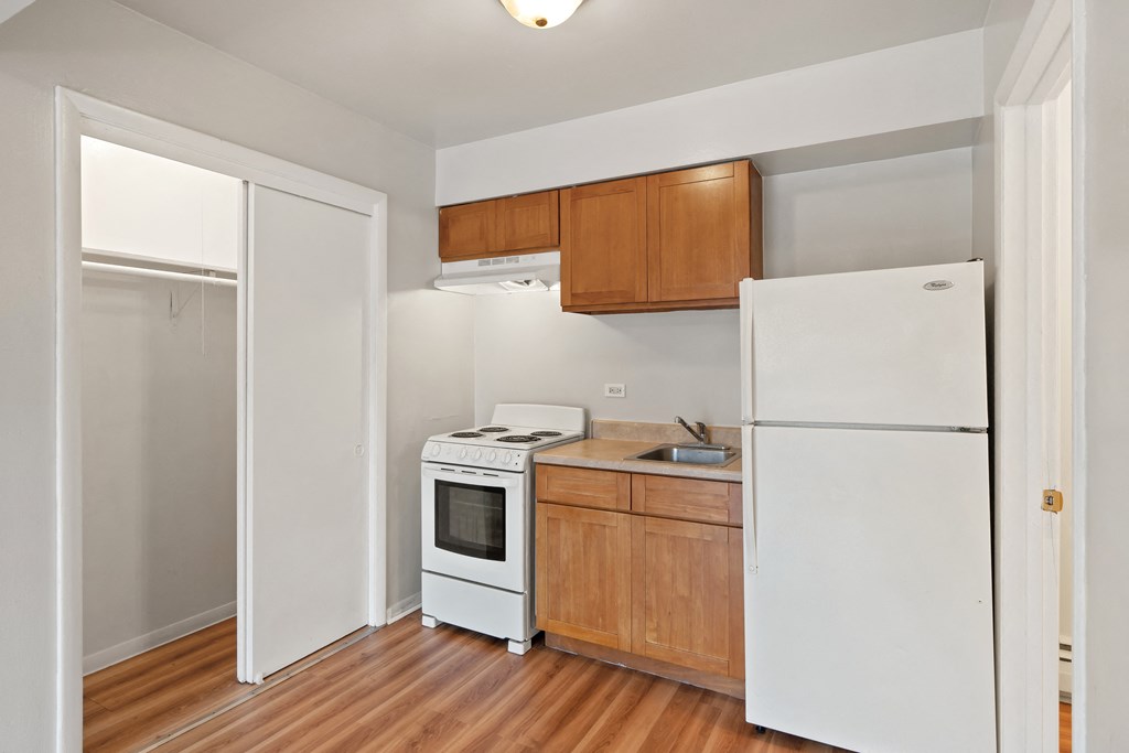 a kitchen with wood floors and white appliances