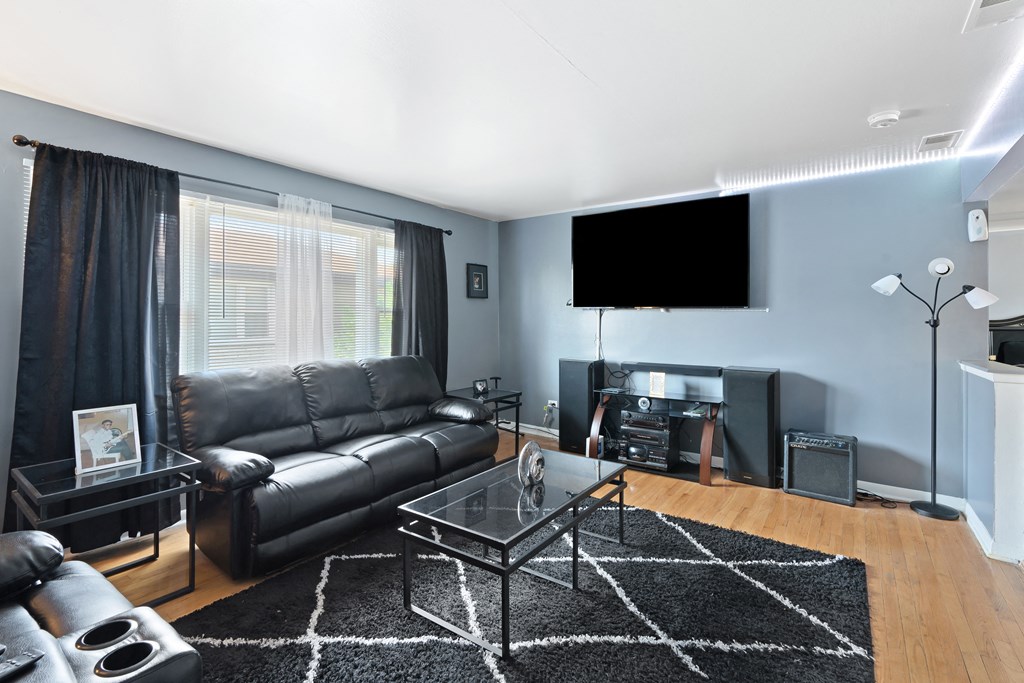 a living room with a couch coffee table and a tv on the wall