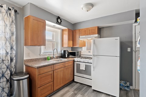 a kitchen with wood cabinets and white appliances