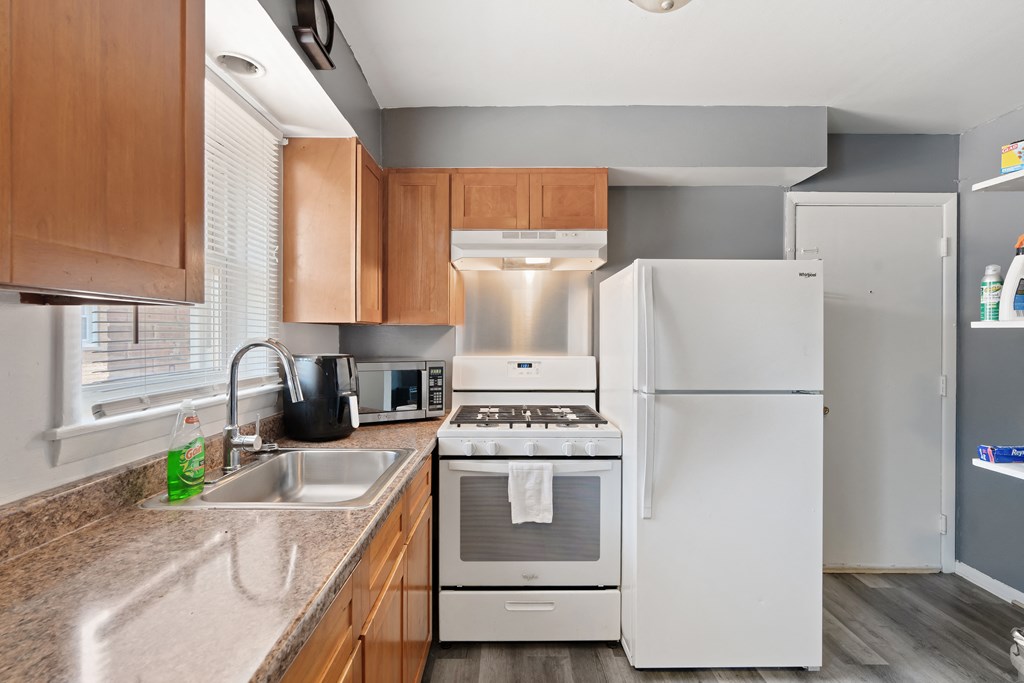 a kitchen with wooden cabinets and a white refrigerator