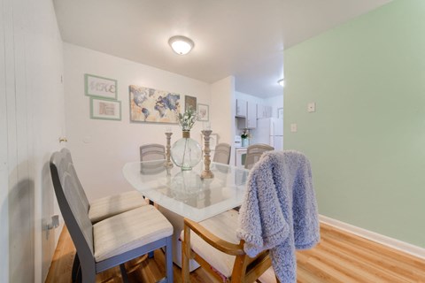 A dining room with a white table and chairs.