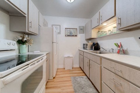 A kitchen with a white oven and wooden cabinets.