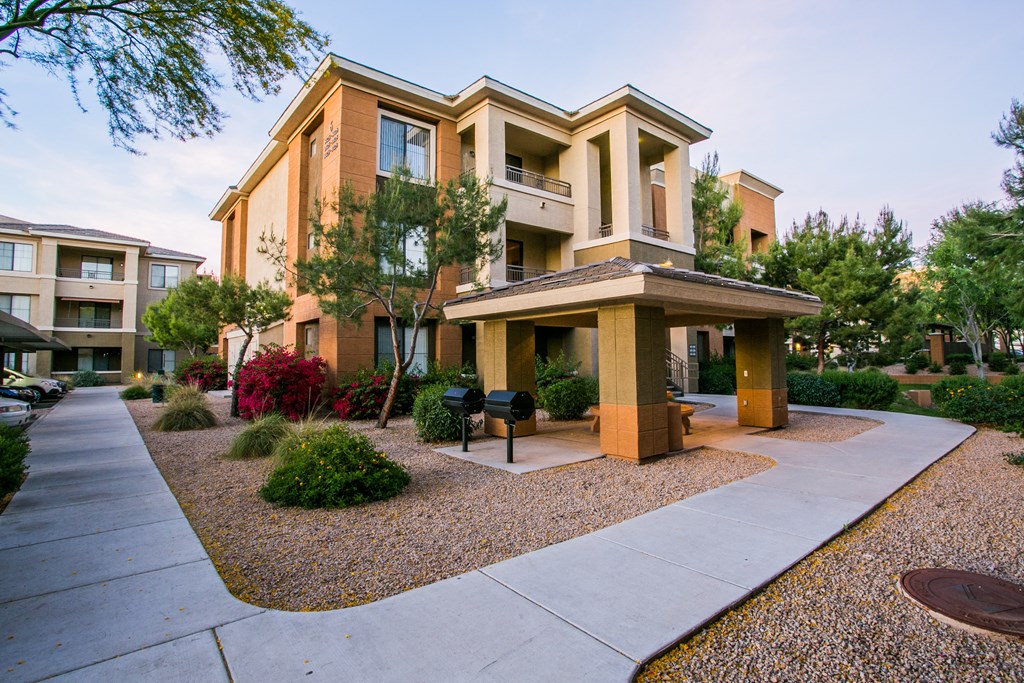 an apartment building with a walkway and a sidewalk